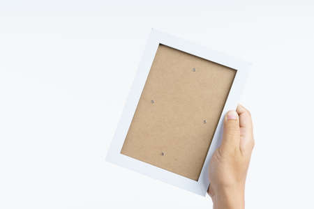 Hand holding blank picture wooden frame on white background