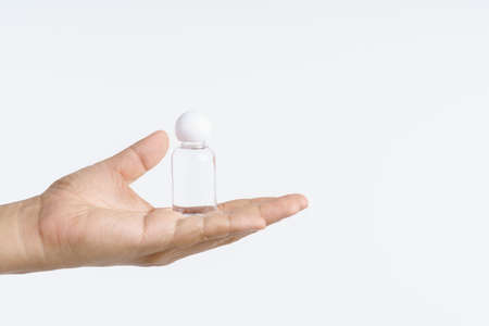 Hand holding small plastic water bottle on white backgroundの写真素材