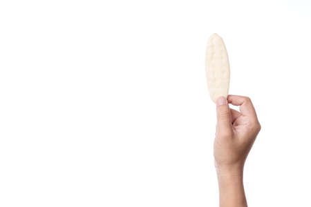 Hand holding baked jasmine rice cracker biscuit, a clean food snack for kid or diet person on white...