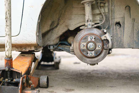 Empty car wheel lug nut holder at tyre changing service with trolley jack