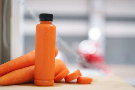 Cold pressed pure carrot vegetable juice from slow juicer in plastic bottleの写真素材