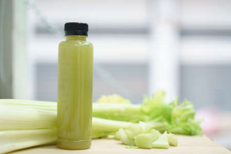 Cold pressed pure celery vegetable juice from slow juicer in plastic bottleの写真素材