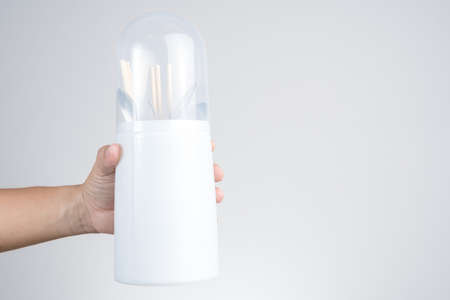 Hand holding anti dust plastic kitchen holder for spoon, fork and chopstick on white background