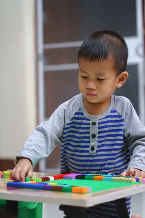 Asian boy about 2 year and 5 months is playing building blocksの写真素材