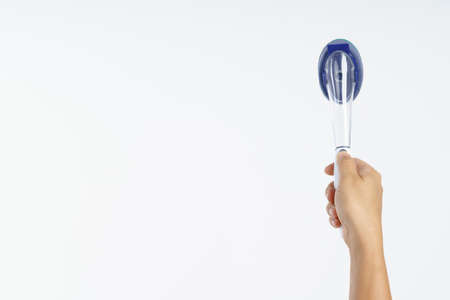 Hand holding new sponge brush with plastic handle on white backgroundの写真素材