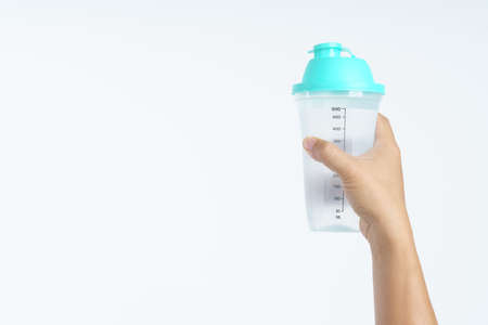 Hand holding plastic water bottle with 500ml gauge on white backgroundの写真素材