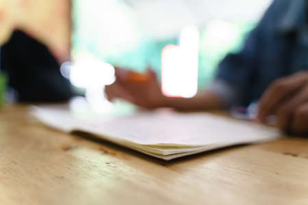 Blurred picture of the book with man studying as backgroundの写真素材