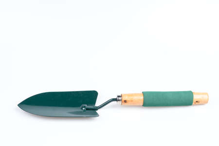 Green garden shovel with wooden handle on white background