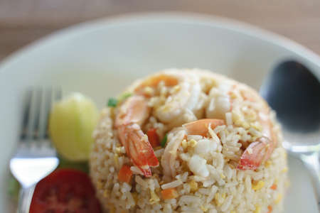 Eating stir fried rice with shrimp or prawn, an Asian traditional food with fork and spoonの写真素材