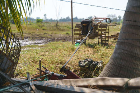 Walking tractor engine draining, pump water for agriculture at Asian countrysideの写真素材