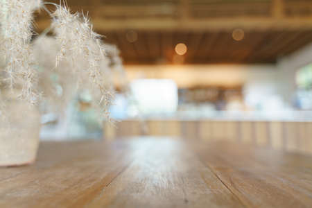 Wooden table at the coffee cafe with beautiful dry grass Poaceae wild spike savanna flower decorationの写真素材