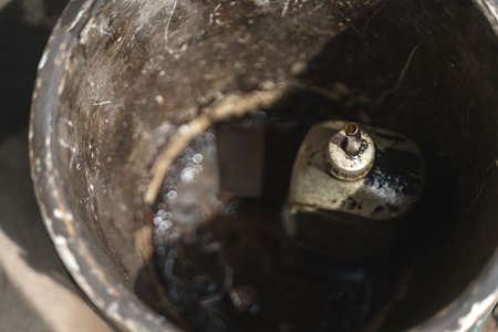 Old lubricating oil bottle in engine lube changing bucketの写真素材