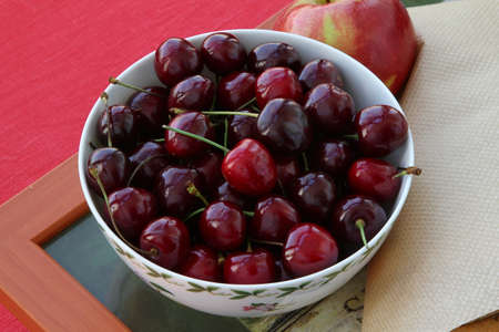 Ripe sweet cherry in a porcelain piala on the trayの写真素材