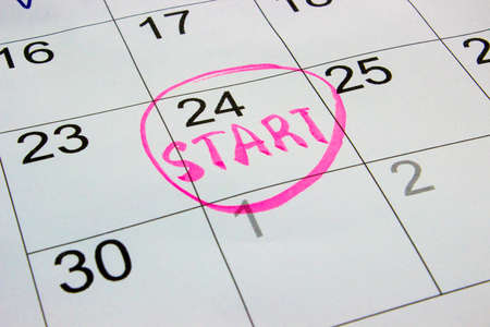 Photo closeup of dates on calendar page with pink marker inscription start