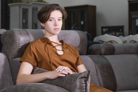 Portrait of a beautiful young girl who is sitting in a beautiful expensive chair