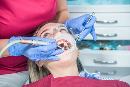 A dentist examines a patient, close-up of a patient with an open mouth next to which dental objects....