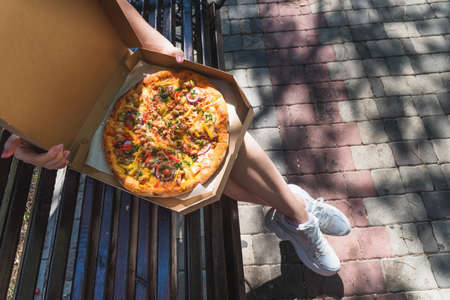Close-up of a pizza box on the street. The concept of fast food, food delivery and lunch in natureの写真素材