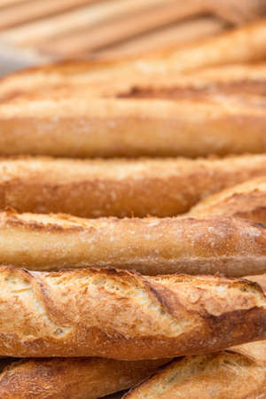 Freshly baked French baguettes lie on a light-colored surface. Rustic handicraft bread, handmade