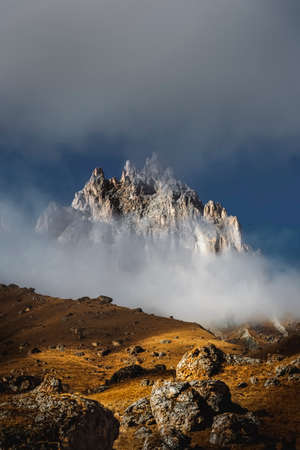 Mountain peaks in the clouds against the backdrop of a beautiful sunset. Travel and hiking conceptの写真素材
