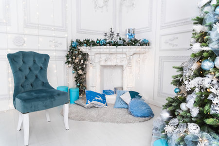 Christmas tree with blue and white toys in the interior. Christmas card with white and blue decor.の写真素材