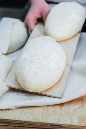 Baker making bread , man hands , kneading a dough , cooking coat.The concept of small bakeries,...