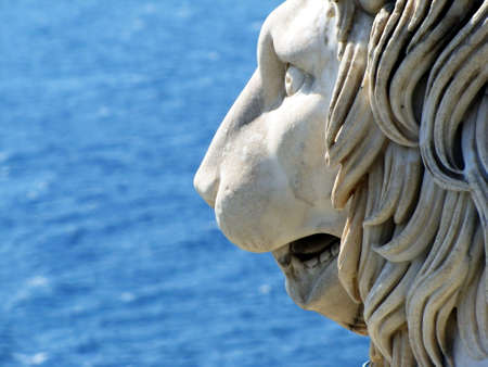 The statue head of lion against the background of the seaの写真素材