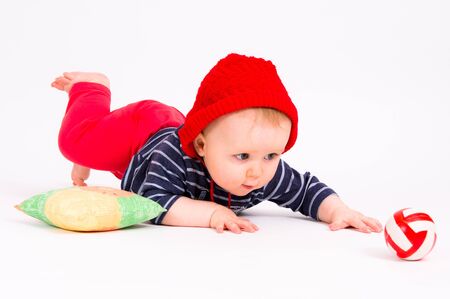 Little child baby crawling for the red ball