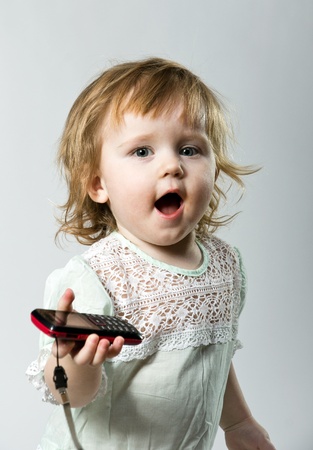 Cute little child with mobile phone on white backgroundの写真素材