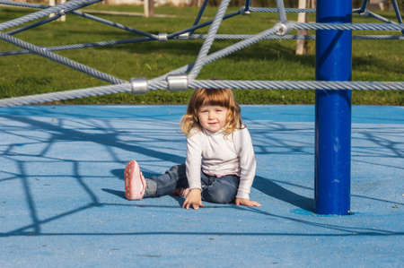 Cute little girl on playground. Sunny day.の写真素材