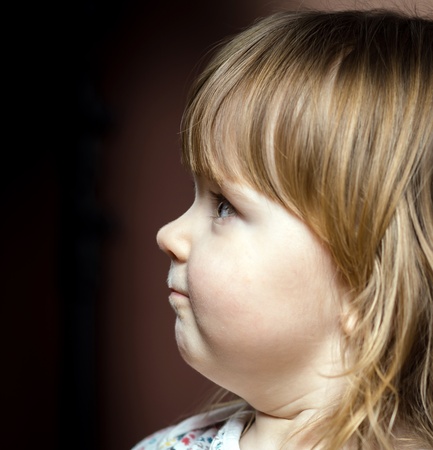Cute little baby portrait. Profile view. Surprising child.の写真素材