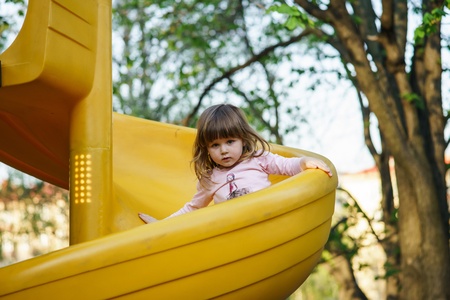 Cute little girl playing on child playground. Moscow.
