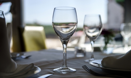Fine restaurant dinner table setting by wineglass and napkin
