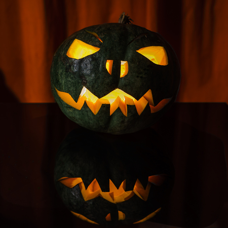 Green halloween pumpkin highlighted from the insideの写真素材