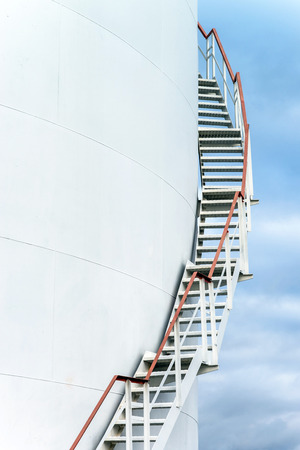 Tall staircase to big oil tank in refineryの写真素材