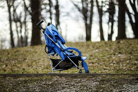 Blue baby stroller standing in spring parkの写真素材