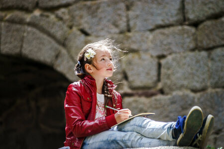 Teenage girl sitting and painting in old castle