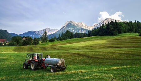 Agrimotor on the field in Austria, mountains, evening