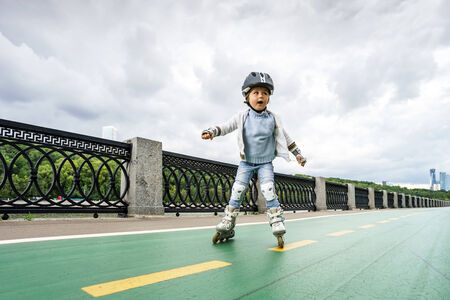 Cute little girl learning rollerskating in public parkの写真素材