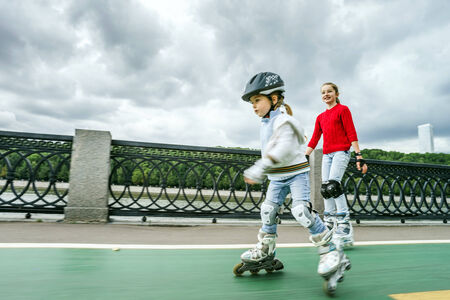 Cute little girl learning rollerskating in public parkの写真素材
