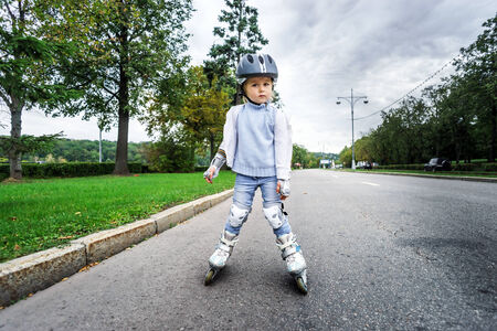 Cute little girl learning rollerskating in public parkの写真素材