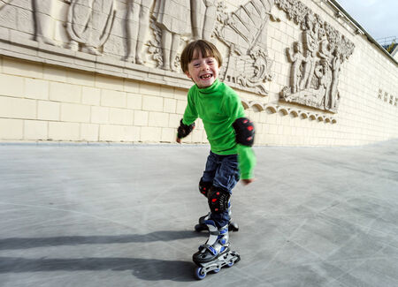 Little preschooler boy learning rollerskating in public parkの写真素材