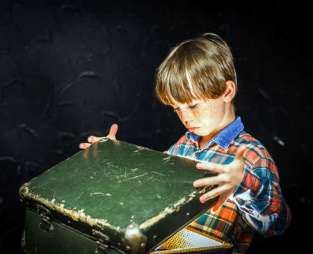 Little boy finding treasure inside a suitcase