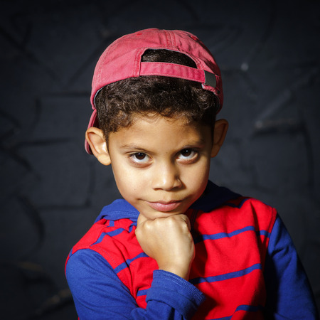 Emotional little black afro-american boy posing in studio