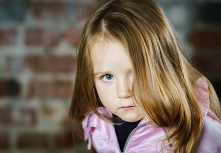 Cute little girl studio portrait, serious child