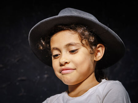 Cute little african-american girl in hat portrait on black