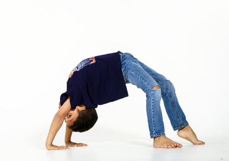 Young active afro-american boy doing gymnastics isolsted on white backgroundの写真素材