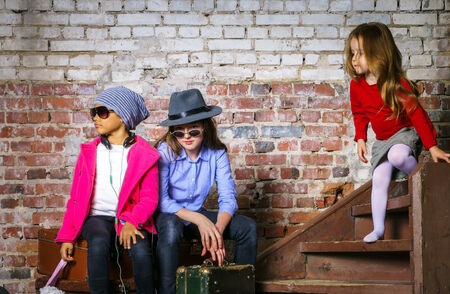 Multi-ethnic children group portrait in studio on brick-wall backgroundの写真素材