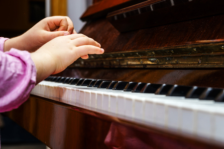 Little girl studing to play the piano at homeの写真素材