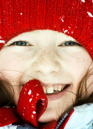 Smiling cute preschooler girl winter portrait, snowy weatherの写真素材