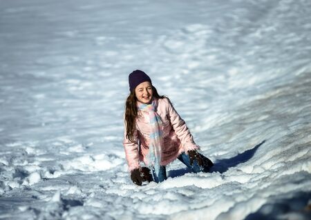 Cute teenage girl playing in white snow, sunny winter day, Alsaceの写真素材
